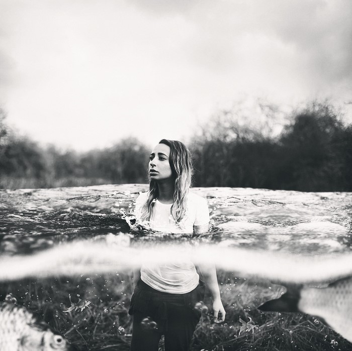 Woman standing in water with fish