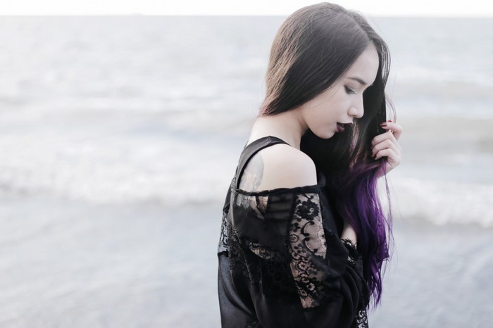 Woman with purple hair at the beach
