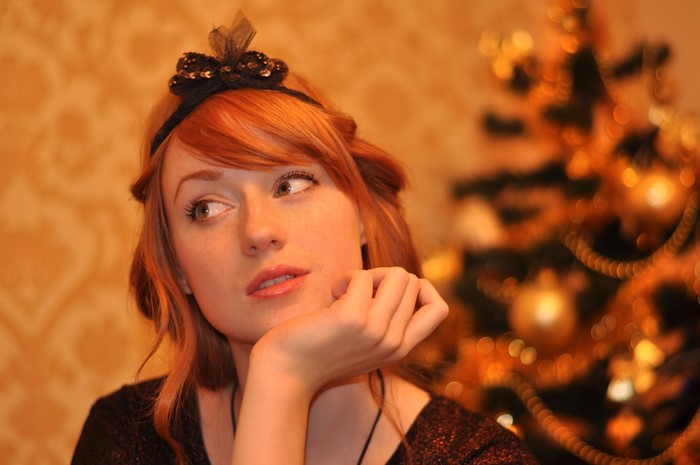 Woman with red hair and a black hair bow