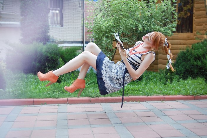 Woman reading a book while levitating outdoors