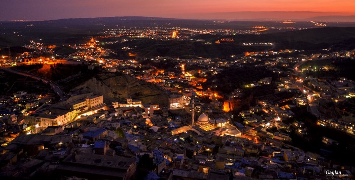 Aerial view of a city at dusk with lights