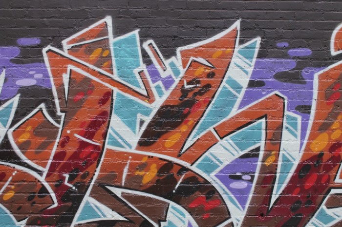 Graffiti mural with orange, blue, and purple abstract shapes