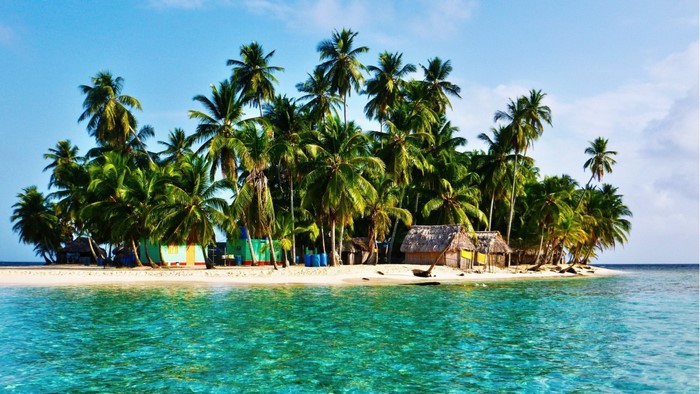 Tropical island with palm trees and huts in the Caribbean
