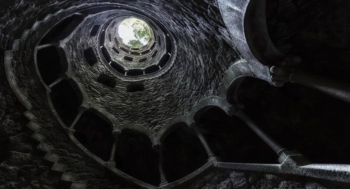 Spiral staircase in a stone well looking up