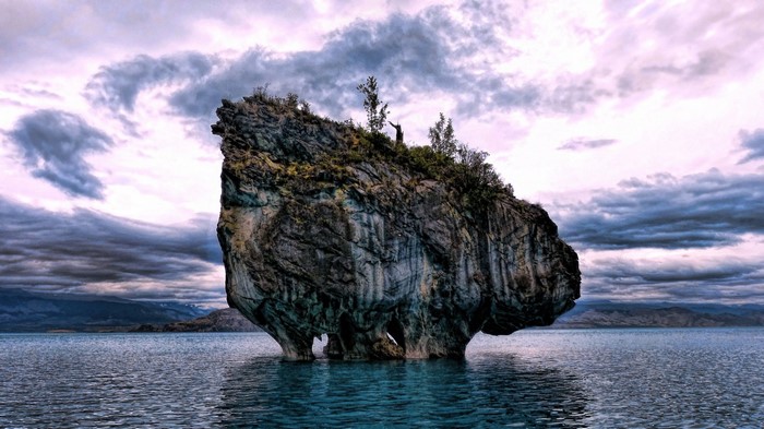 Rock formation in a lake with dramatic clouds