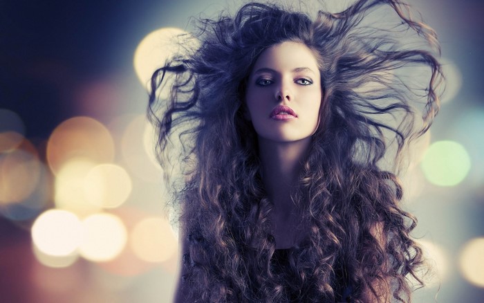 Woman with long curly hair and blue eyes