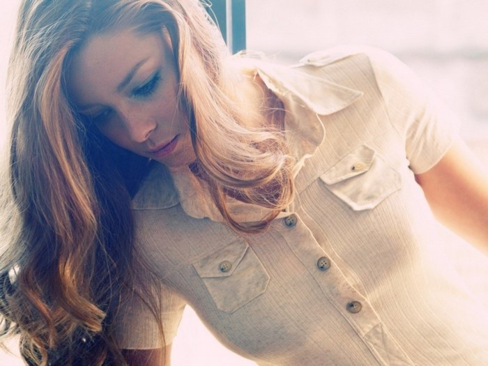 Woman with long blonde hair wearing a collared shirt