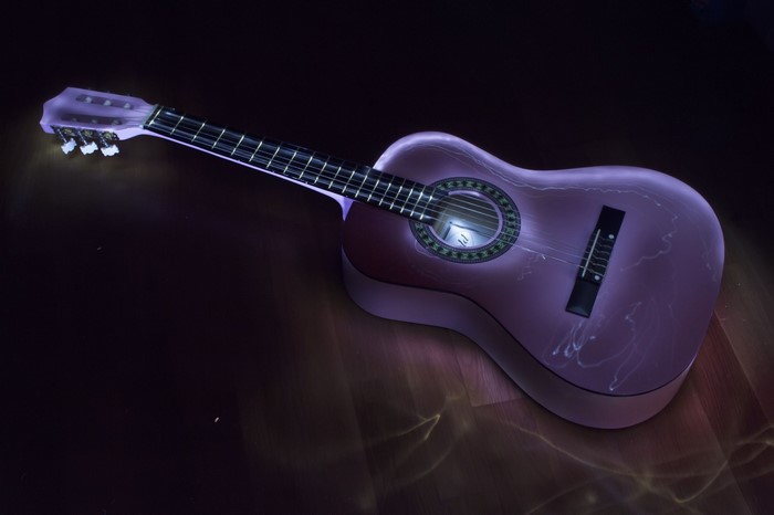 Acoustic guitar with purple lighting