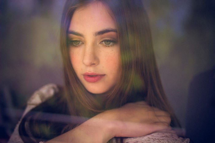 Young woman with freckles looking down