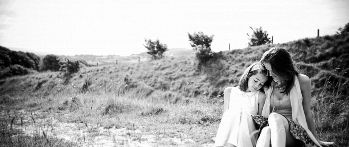 Mother and daughter sitting in a field