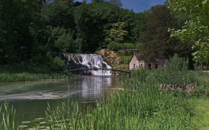 Waterfall and a small house by a lake