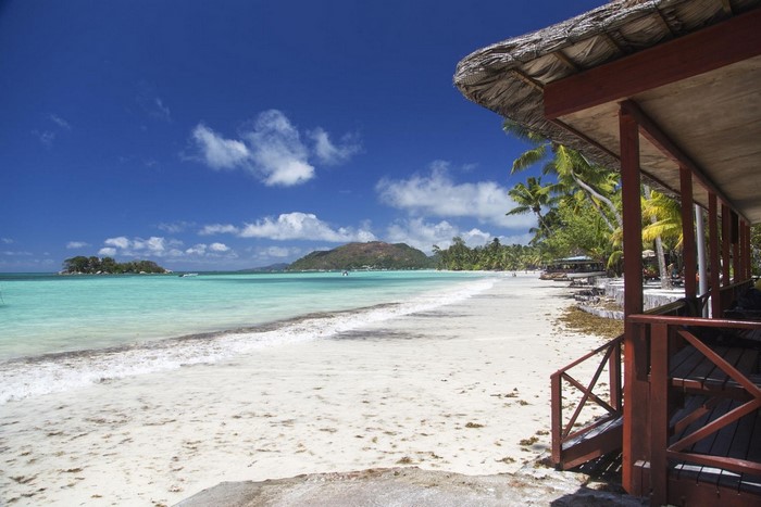 Tropical beach with a thatched-roof hut and turquoise water
