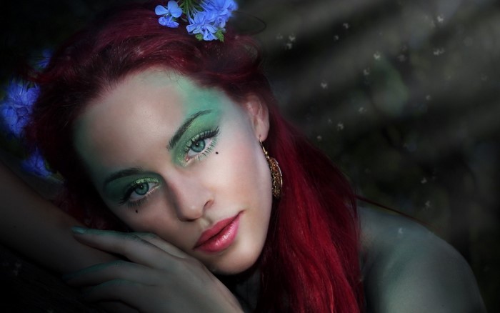 Woman with red hair and green face paint