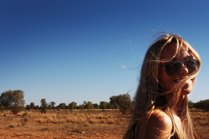 Woman with sunglasses in a dry field