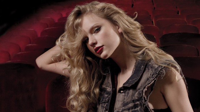 Woman with long blonde hair in a denim vest