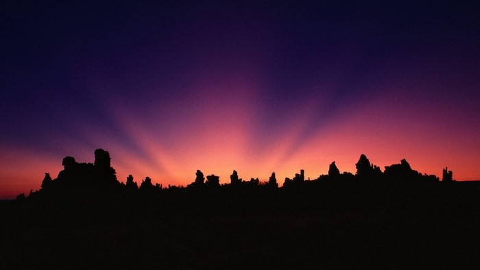 Silhouette of rock formations against a sunset sky