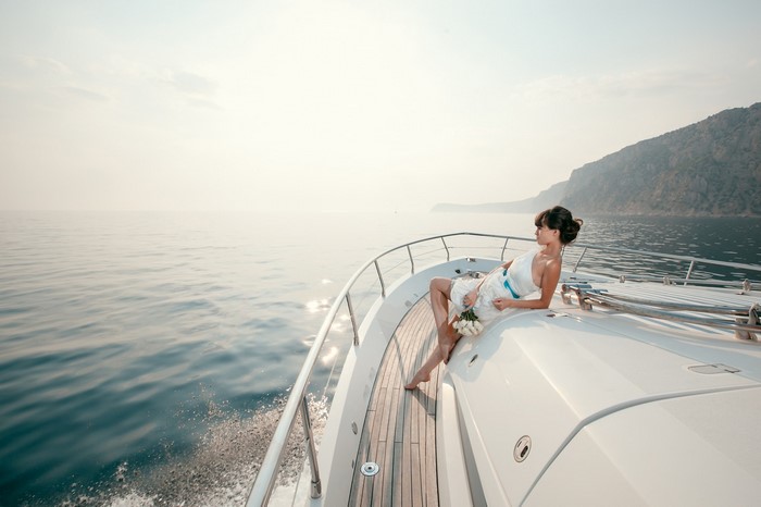 Woman in white dress on a yacht with flowers