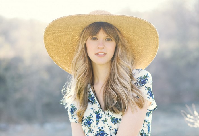 Woman wearing a wide-brimmed hat and floral dress