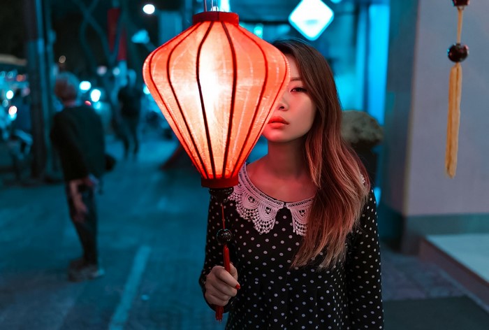 Woman holding a red lantern at night