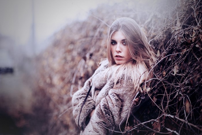 Woman in fur coat in dry brush