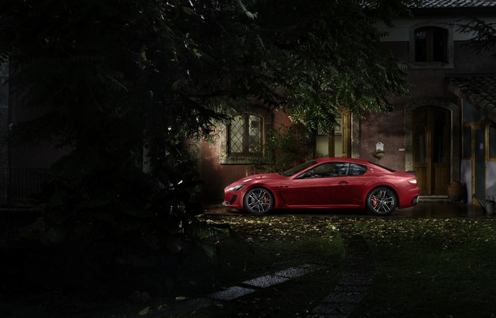 Red Maserati GranTurismo parked at night near a house
