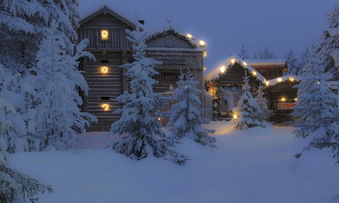 Snowy log cabins decorated with Christmas lights in a forest