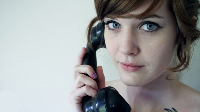 Woman holding a vintage telephone to her ear