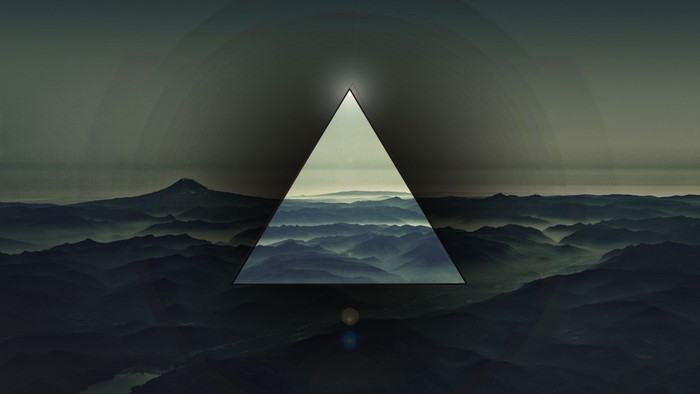 Triangle framing misty mountains and a distant peak