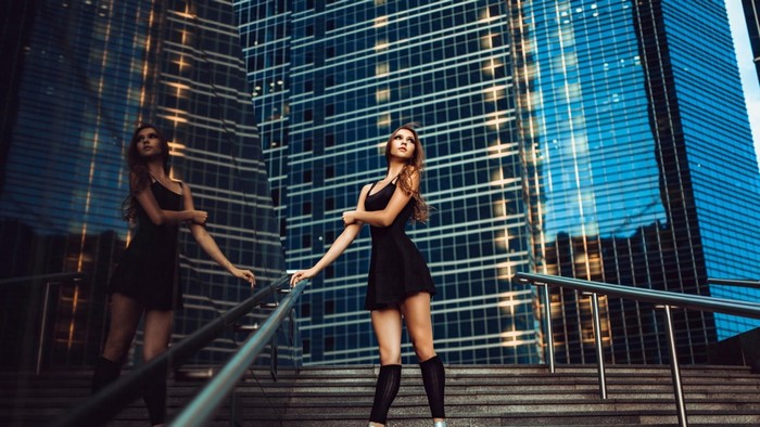Woman in black dress on city stairs