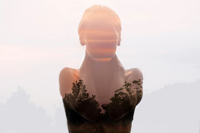 Double exposure of a woman and a forest landscape