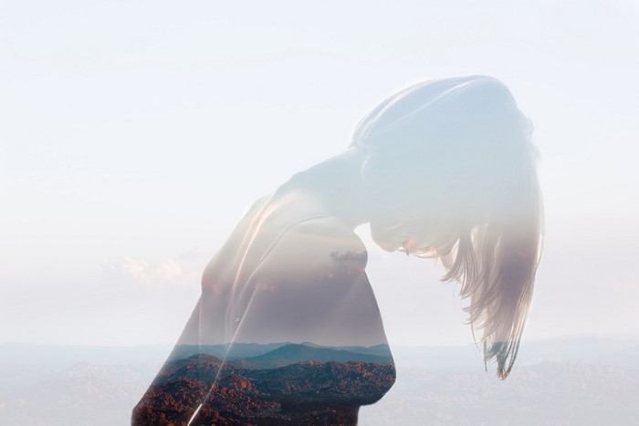 Double exposure of a woman and mountains