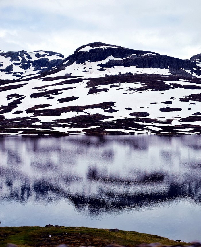 Snow-covered mountains reflected in a calm lake