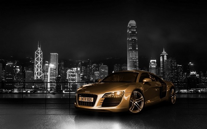 Golden Audi R8 sports car in front of Hong Kong skyline