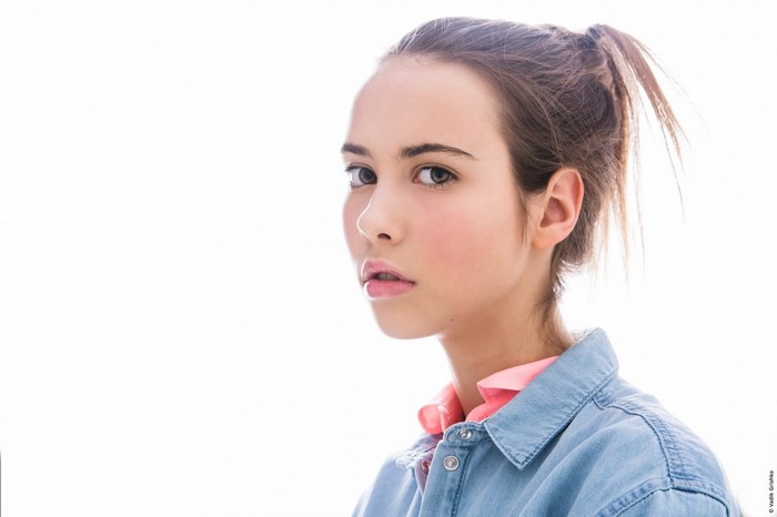 Portrait of a young woman with brown hair in a ponytail