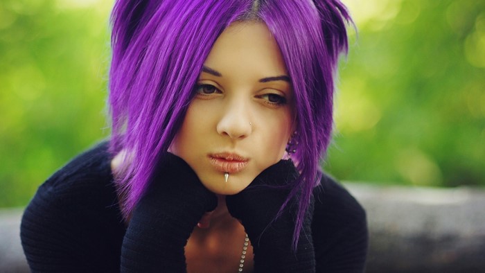 Thoughtful Woman with Vibrant Purple Hair Outdoors