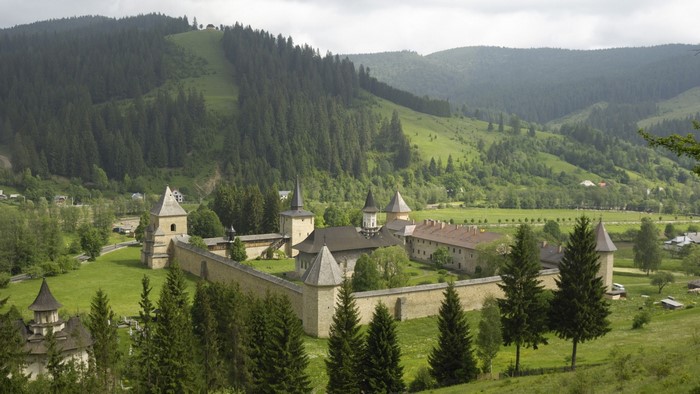 Monastery in a valley with forested hills
