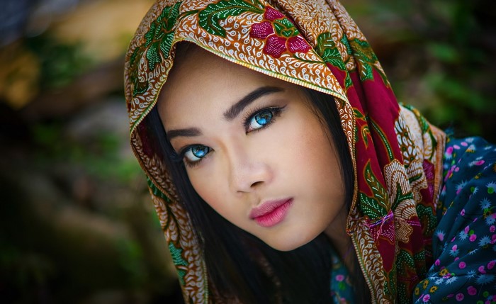 Woman with blue eyes wearing a patterned headscarf