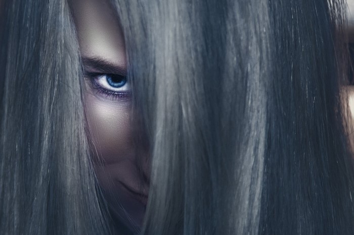 Close up of a woman's face with blue eyes and long hair