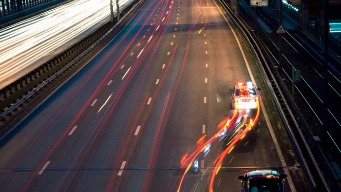 Police car with light trails on a highway at night