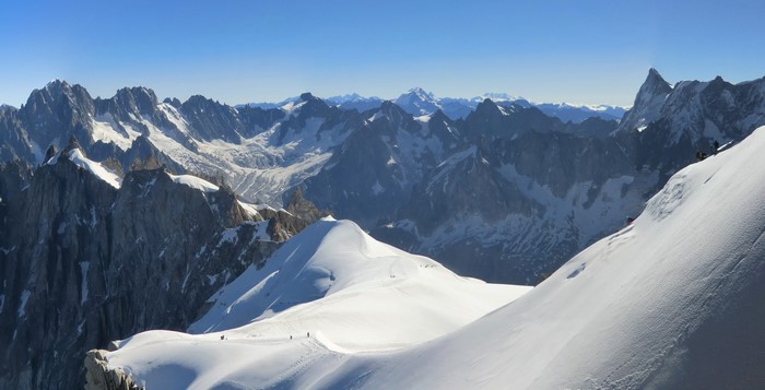 Panoramic view of snow-covered Alps mountains under a clear blue sky