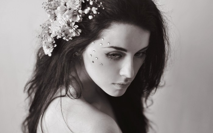 Monochrome portrait of a woman with flowers and rhinestones