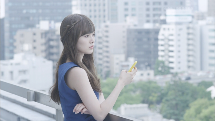 Contemplative Woman in Blue Dress Holding Smartphone