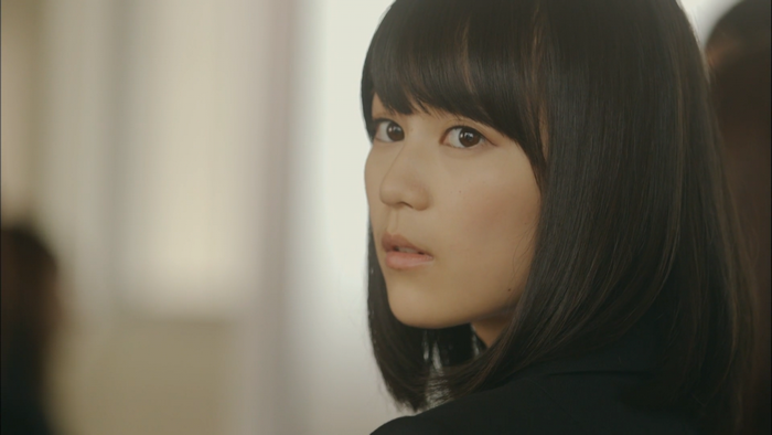 Asian woman with black hair looking over shoulder
