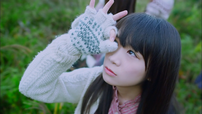 Girl in white sweater and gloves looking away