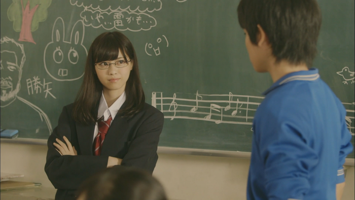 Asian woman in school uniform in front of a blackboard