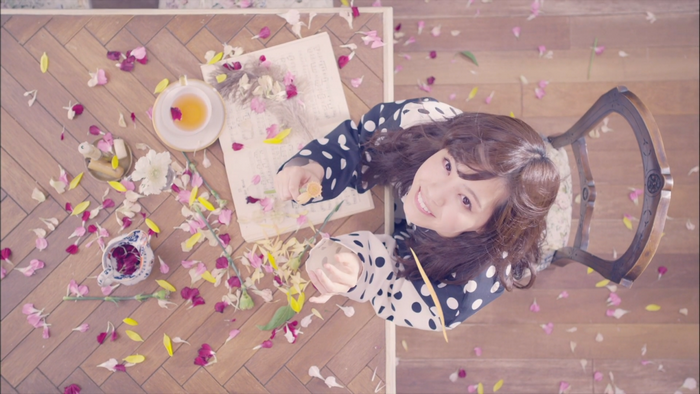 Asian woman in polka dot dress with flowers and tea