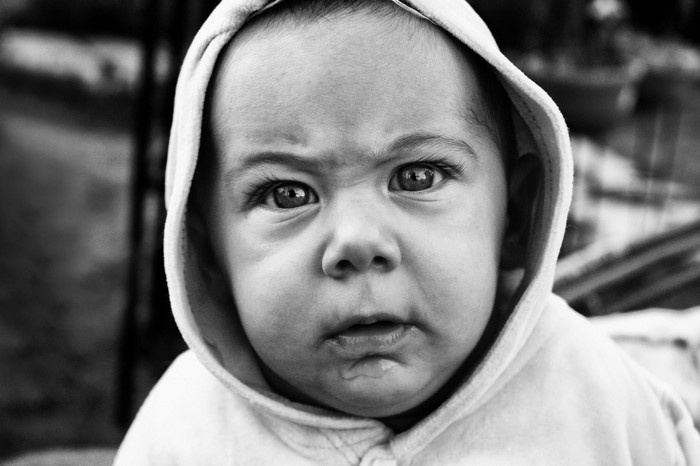 Monochrome portrait of a baby in a hooded sweatshirt