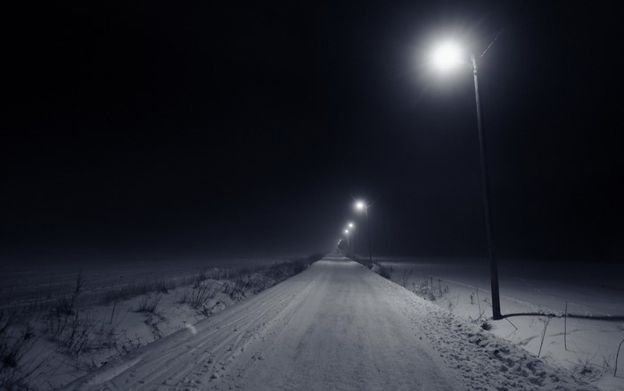Snowy road at night with street lights