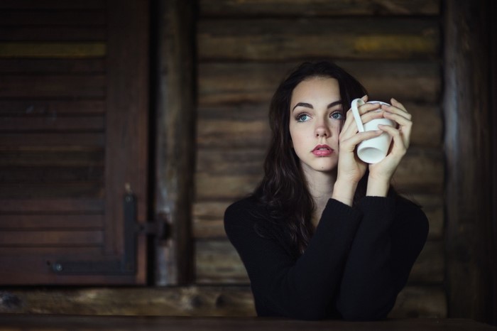 Woman holding a mug, looking away