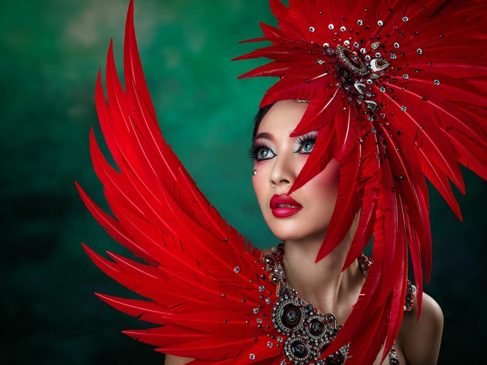 Woman in elaborate red feather costume and headdress